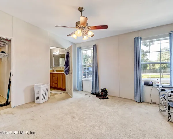 a view of a livingroom with a ceiling fan and window