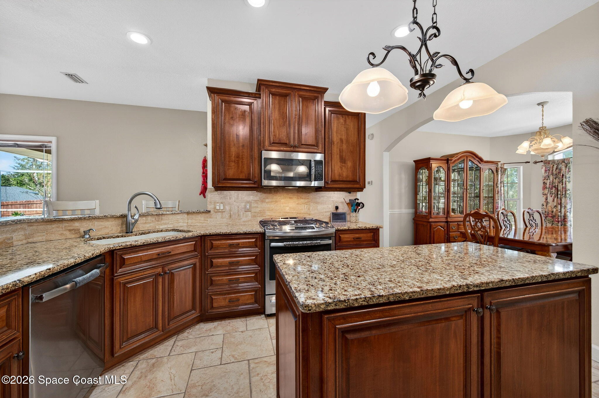 3676 South Ridge Circle Titusville, FL 32796 - Photo 18 of 74 a kitchen with stainless steel appliances granite countertop wooden cabinets and a sink