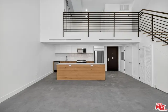 a view of kitchen with stainless steel appliances granite countertop white cabinets and window