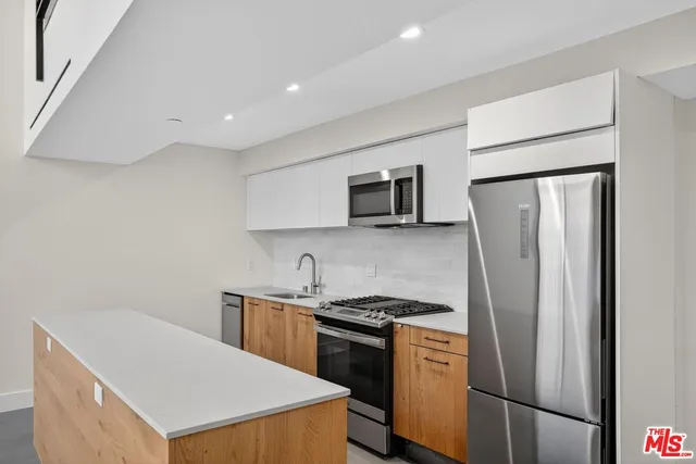 a kitchen with stainless steel appliances a refrigerator sink and microwave