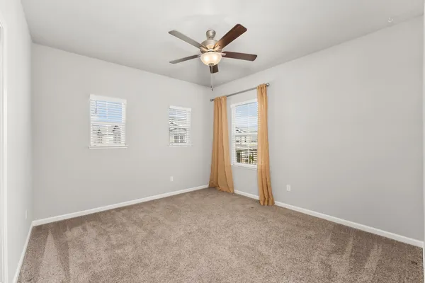 an empty room with window and ceiling fan