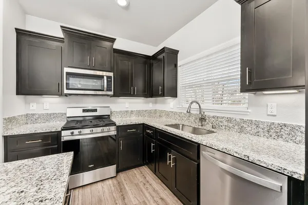 a kitchen with a sink stove and microwave