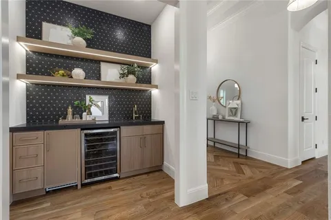 a kitchen with white cabinets and wooden floor