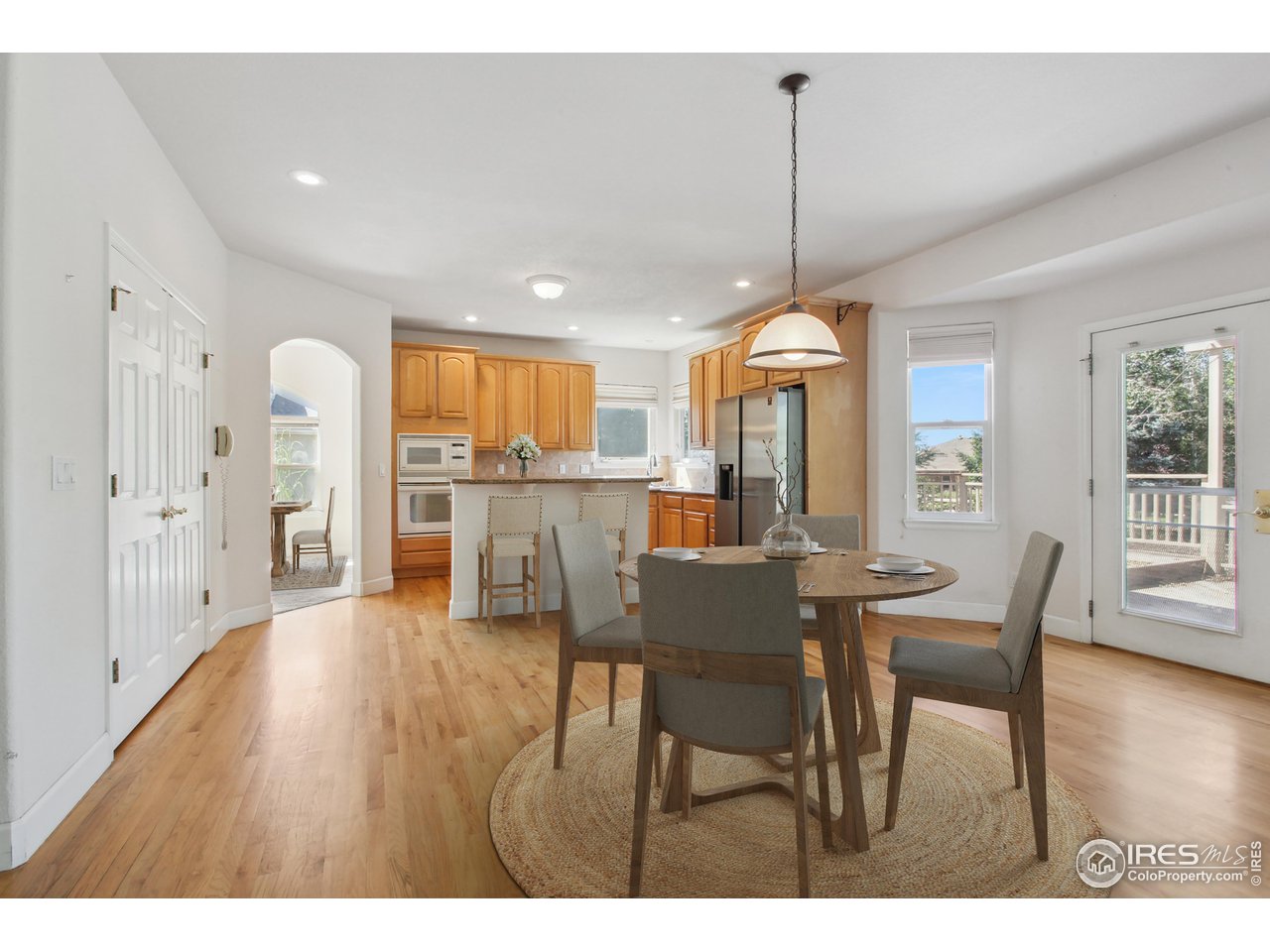6735 Saddleback Avenue Firestone, CO 80504 - Photo 7 of 26 a view of a dining room and livingroom with furniture wooden floor a chandelier
