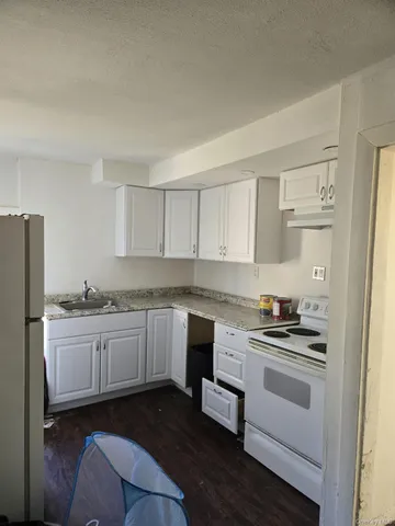 a kitchen with granite countertop white cabinets and white appliances