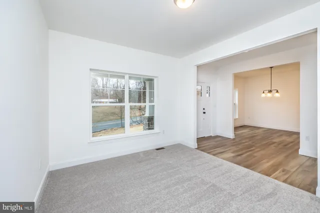 a kitchen with white cabinets and a window