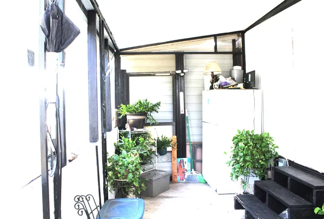 a front view of a house with a large window and flower pot