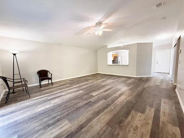 a view of a livingroom with wooden floor and furniture