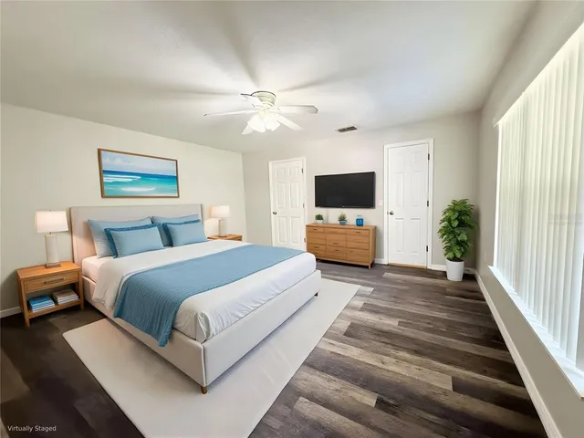 an empty room with wooden floor fan and windows