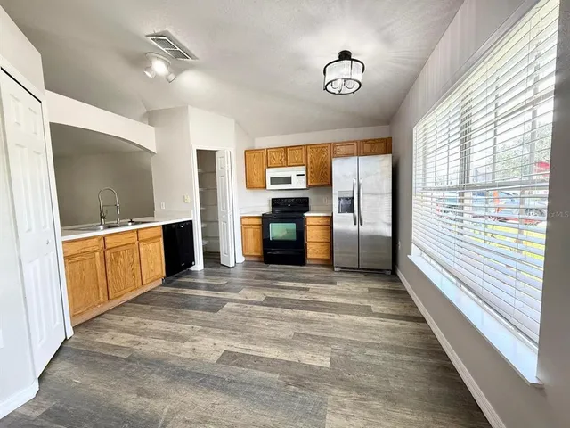 a view of a kitchen with a sink dishwasher and a fireplace