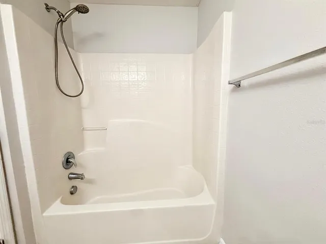 a bedroom with bed tv and window