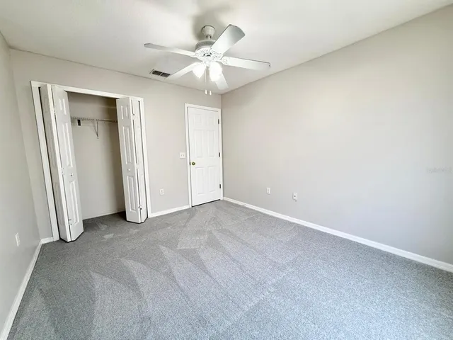 a view of an empty room with a ceiling fan