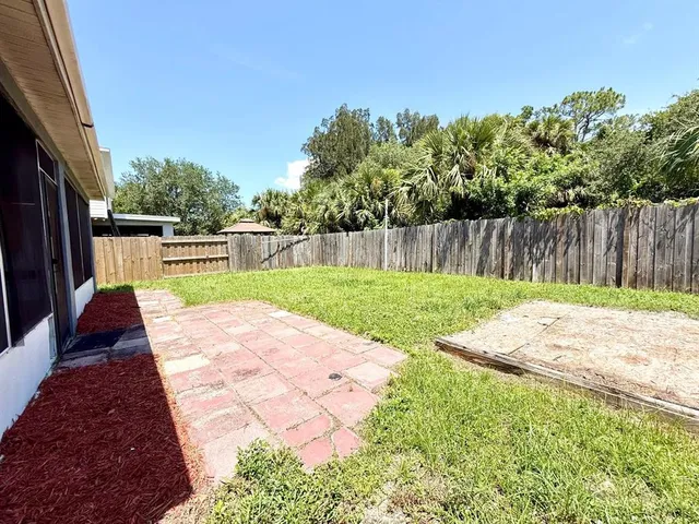 a view of a house with a yard and potted plants
