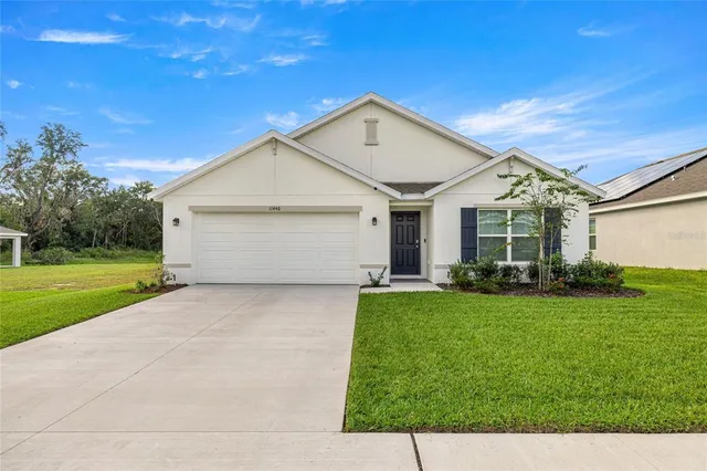 a front view of a house with a yard and garage
