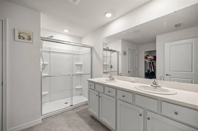 a bathroom with a double vanity sink mirror and shower