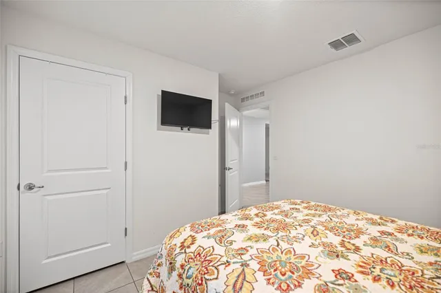 a bedroom with a bed and a flat screen tv