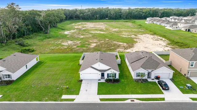 an aerial view of residential houses with outdoor space and pool