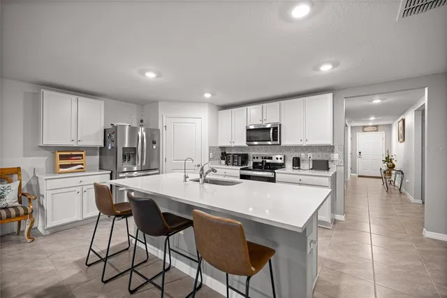 a kitchen with refrigerator and chairs