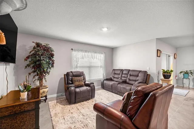 a living room with furniture a flat screen tv and a potted plant
