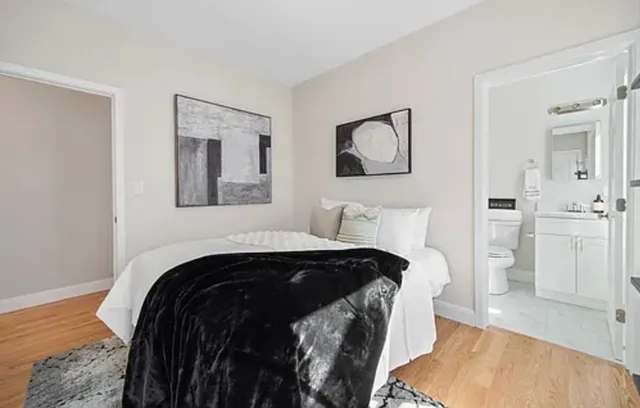 a bedroom with a bed and painting on the wall