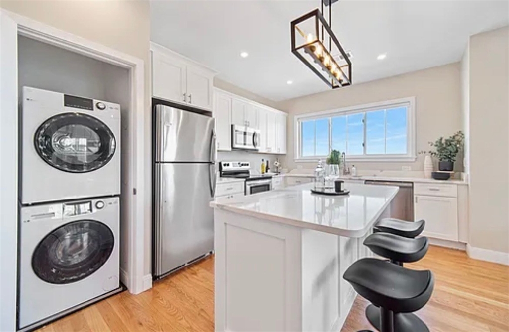 2-4 Hecla Street, Unit 1 Boston, MA 02122 - Photo 4 of 9 a kitchen with stainless steel appliances granite countertop a sink a stove a refrigerator cabinets and chairs