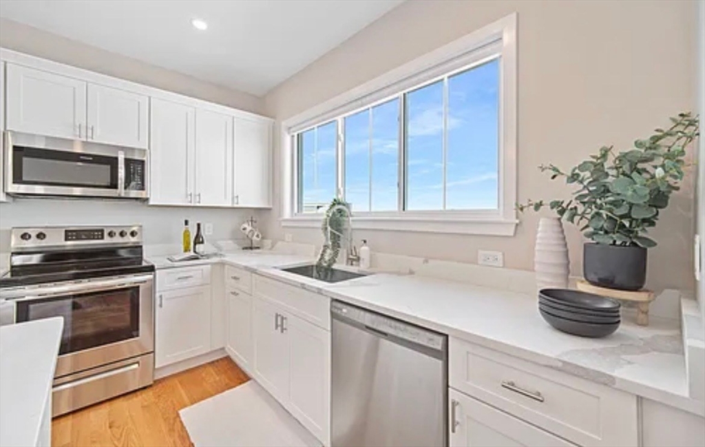 2-4 Hecla Street, Unit 1 Boston, MA 02122 - Photo 6 of 9 a kitchen with a sink stove and microwave