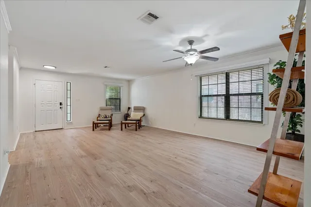 an empty room with windows and ceiling fan