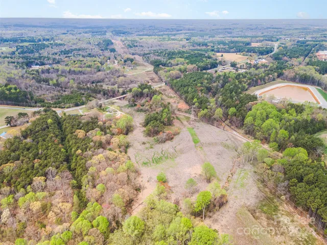 a view of a yard with flower plants and wooden fence