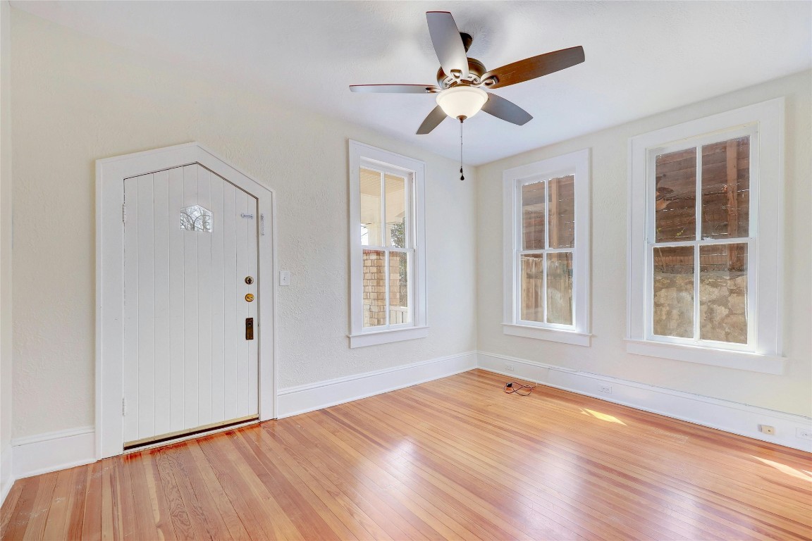 1920 Newning Avenue Austin, TX 78704 - Photo 11 of 26 an empty room with wooden floor chandelier fan and windows