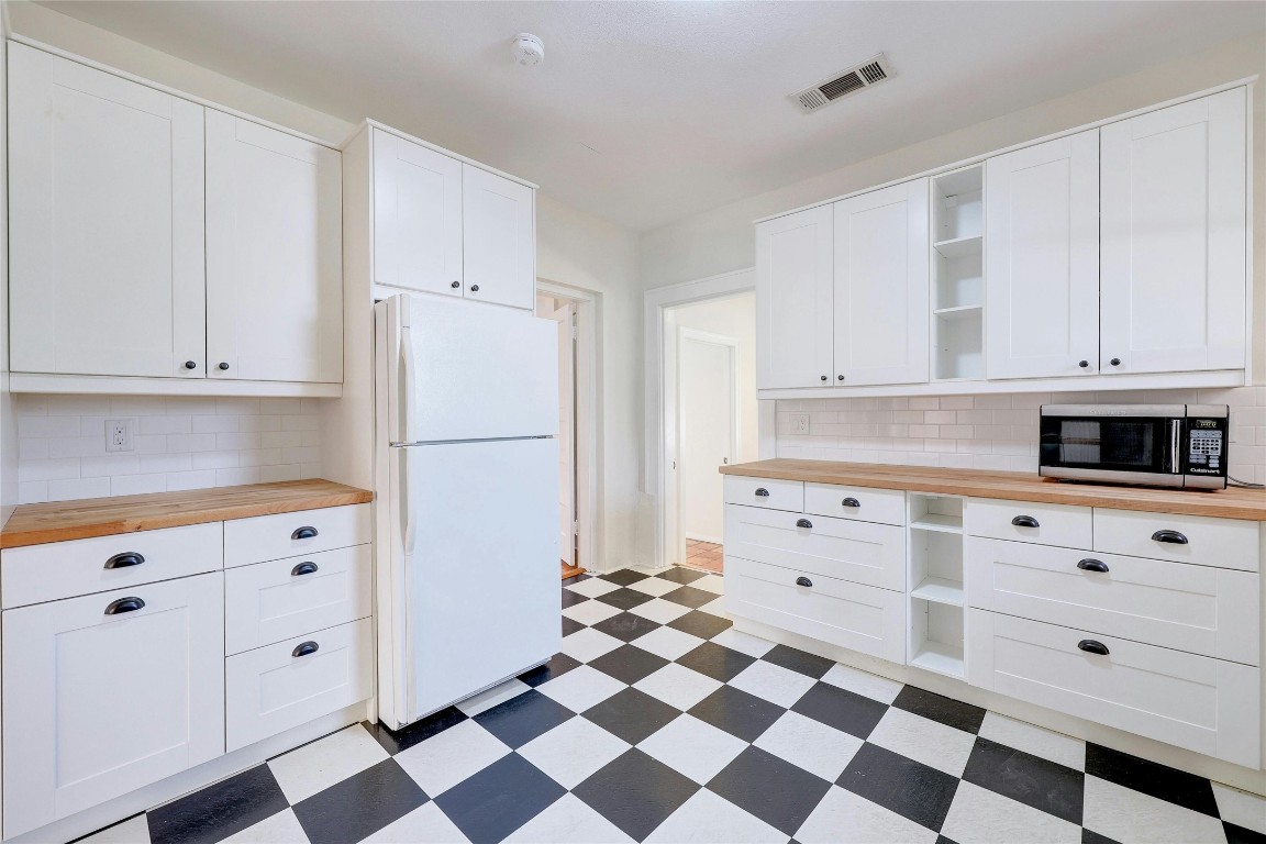 1920 Newning Avenue Austin, TX 78704 - Photo 9 of 26 a kitchen with white cabinets and black appliances
