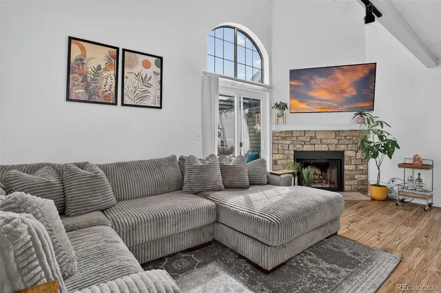 a living room with furniture a flat screen tv and a fireplace