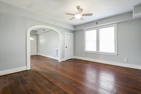 an empty room with wooden floor and window