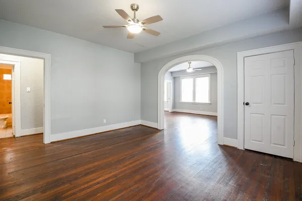 an empty room with wooden floor and window