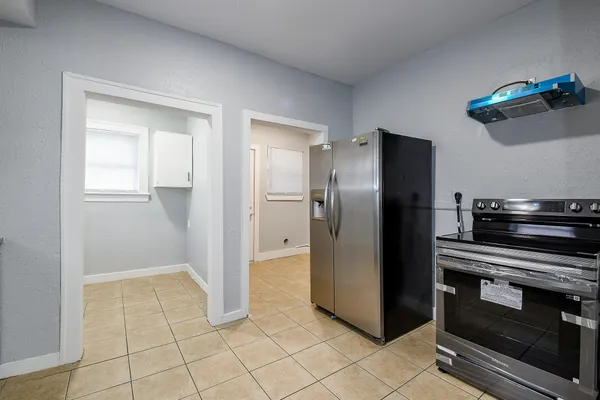 a kitchen with stainless steel appliances granite countertop a refrigerator and a stove top oven