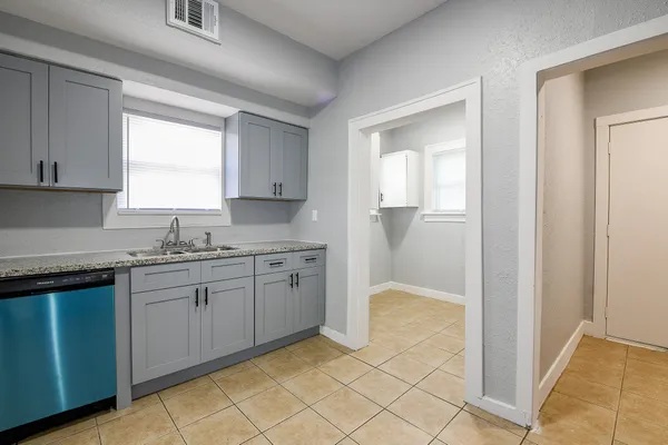 a kitchen with granite countertop white cabinets and sink