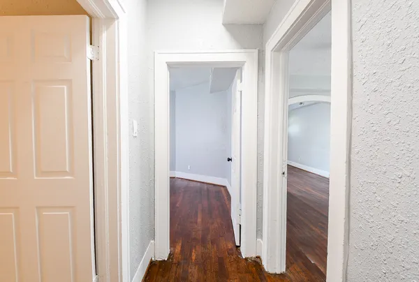 a view of a hallway with wooden floor