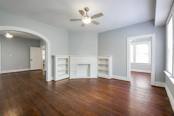 an empty room with wooden floor and window