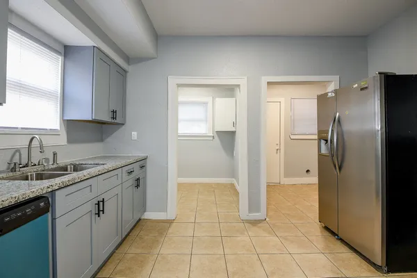 a kitchen with a sink a refrigerator and cabinets