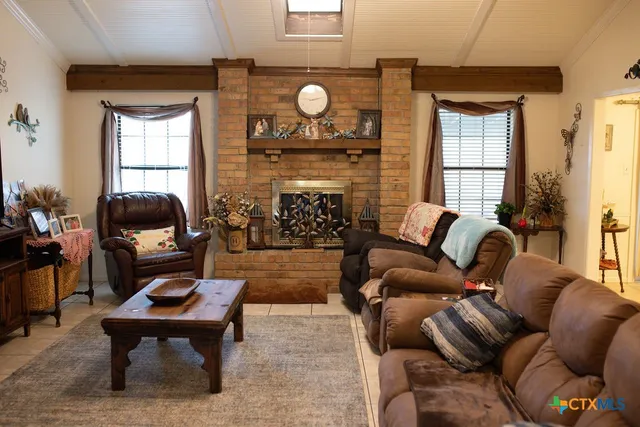 a living room with furniture a fireplace and a window