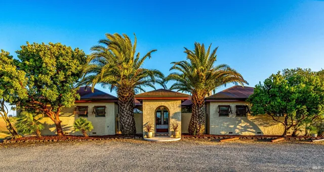 a view of a patio with a table and chairs under an umbrella