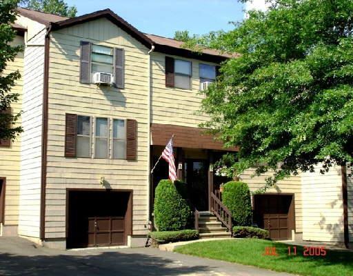 95 Country Hill Road, Unit 95 Naugatuck, CT 06770 - Photo 1 of 1 a front view of a house with a yard and garage