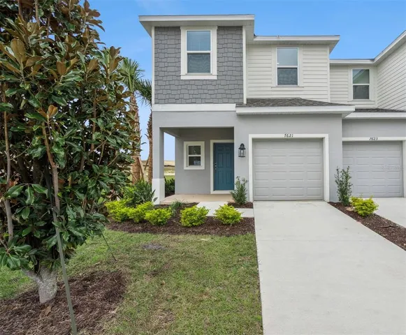 a front view of a house with a garden and garage