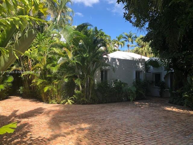 3797 El Prado Boulevard Miami, FL 33133 - Photo 2 of 26 a view of a house with a yard and tree s