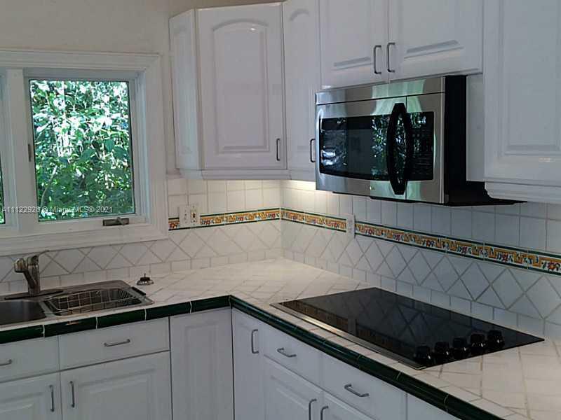 3797 El Prado Boulevard Miami, FL 33133 - Photo 12 of 26 a kitchen with a sink and cabinets