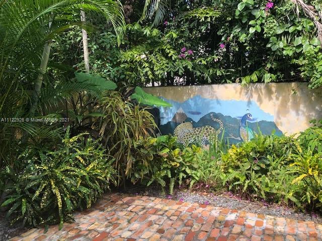3797 El Prado Boulevard Miami, FL 33133 - Photo 20 of 26 a view of a garden with a bench in a garden