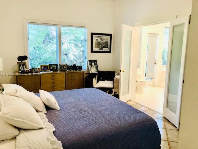 3797 El Prado Boulevard Miami, FL 33133 - Photo 7 of 26 a bedroom with a bed and wooden floor