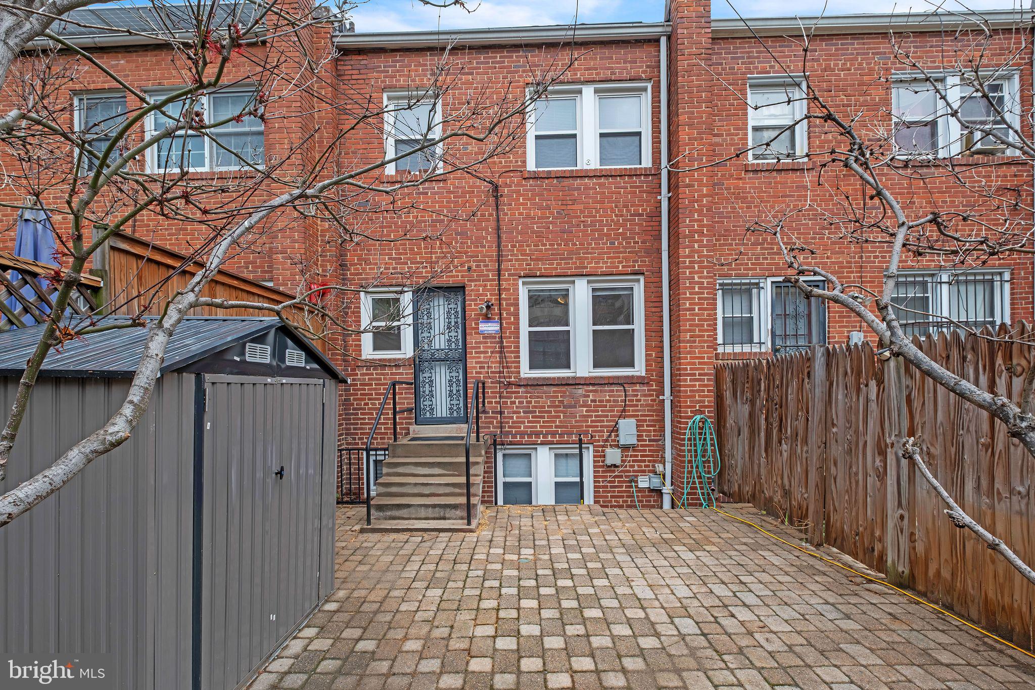 1407 K Street Southeast Washington, DC 20003 - Photo 24 of 30 a backyard of a house with wooden fence and a brick wall