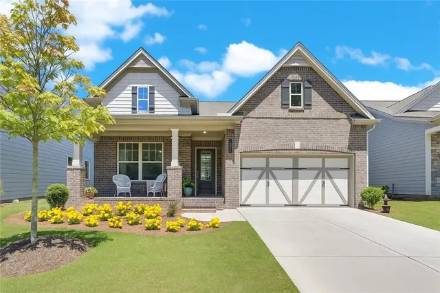 a front view of a house with a yard outdoor seating and garage
