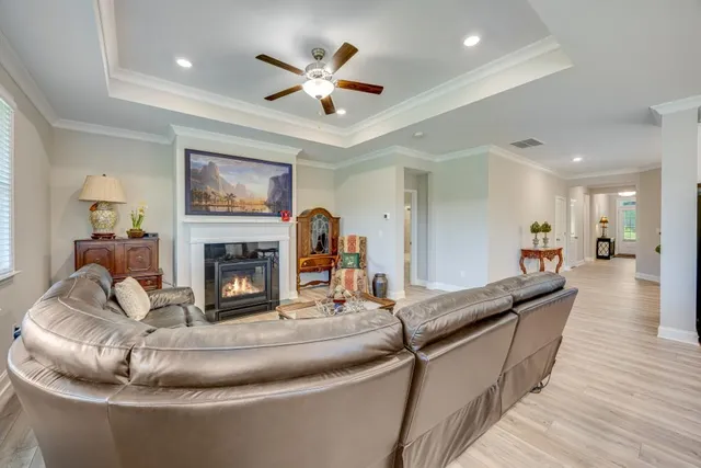 a living room with furniture kitchen view and a wooden floor