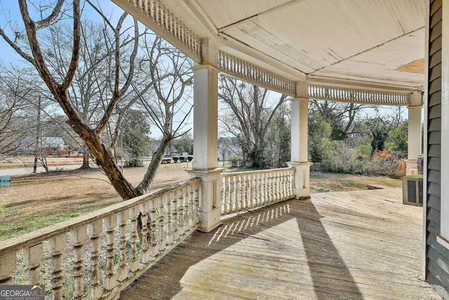 a view of a hallway with wooden floor and living room